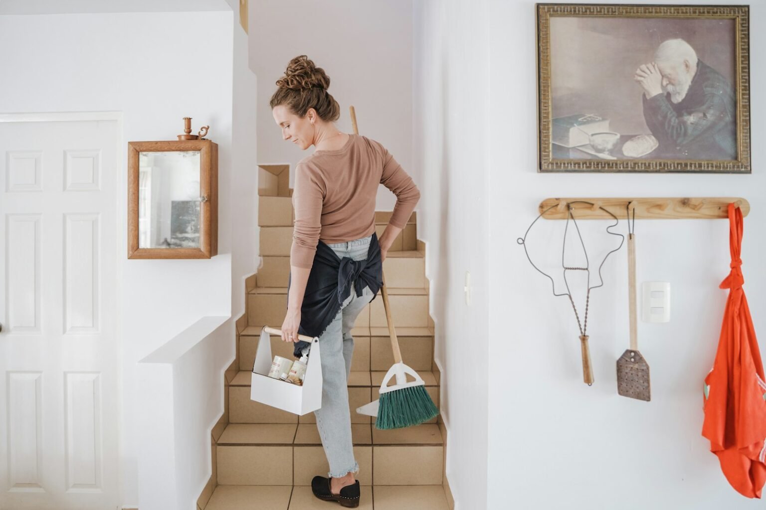 Cleaning company owner carrying a caddy of supplies upstairs to a residential job booked through local search