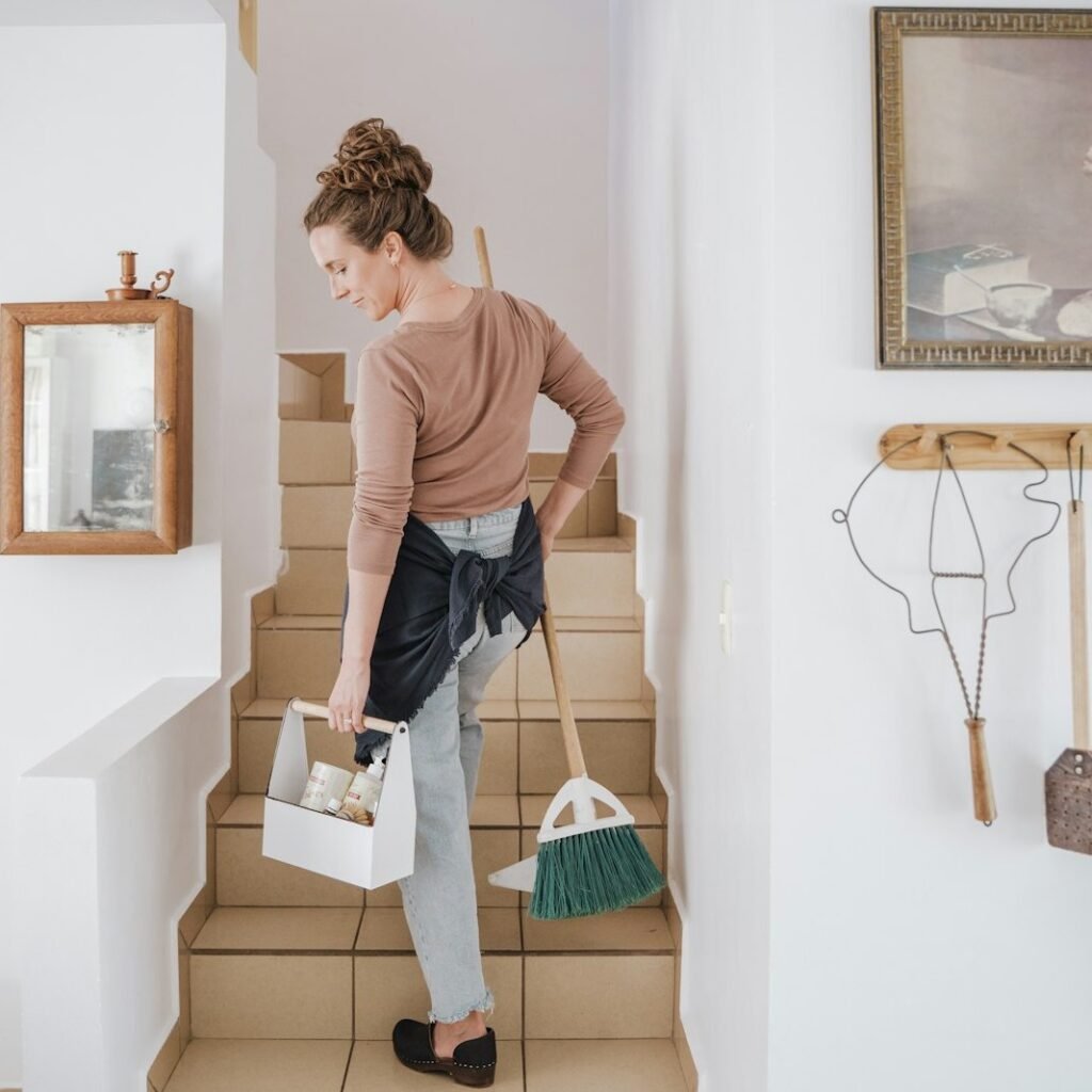 Cleaning company owner carrying a caddy of supplies upstairs to a residential job booked through local search