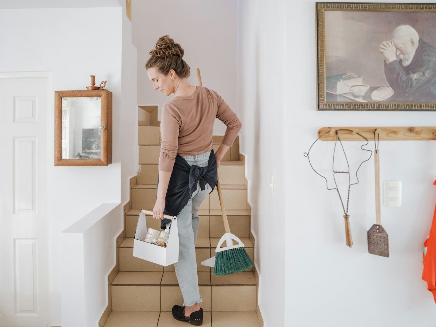 Cleaning company owner carrying a caddy of supplies upstairs to a residential job booked through local search